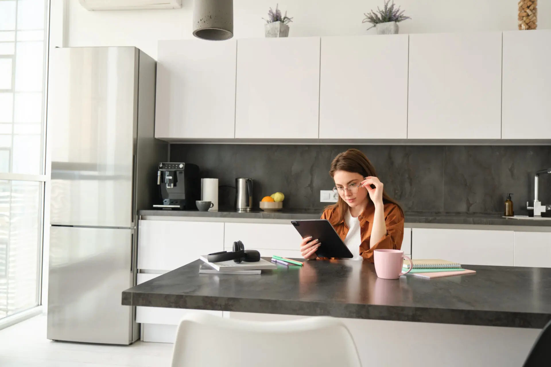 portrait young woman studying home girl reading something tablet sitting kitchen scaled